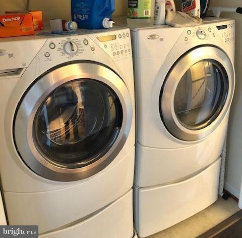 clothes washing area with washing machine and dryer