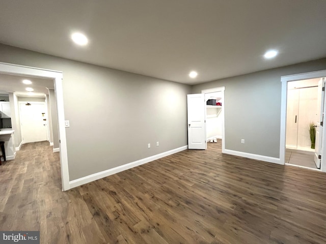 unfurnished bedroom with a walk in closet and dark wood-type flooring