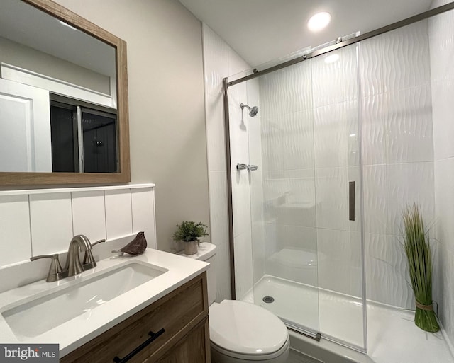 bathroom with vanity, a shower with shower door, and toilet