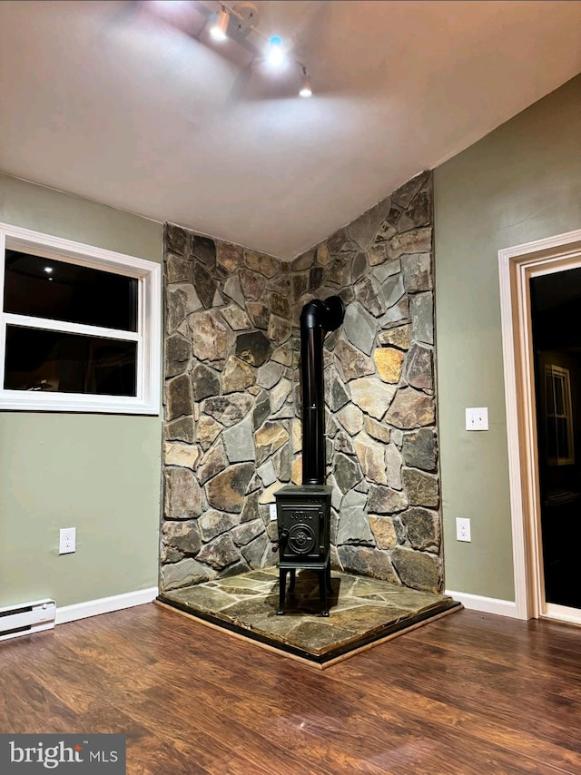 room details with hardwood / wood-style floors and a wood stove