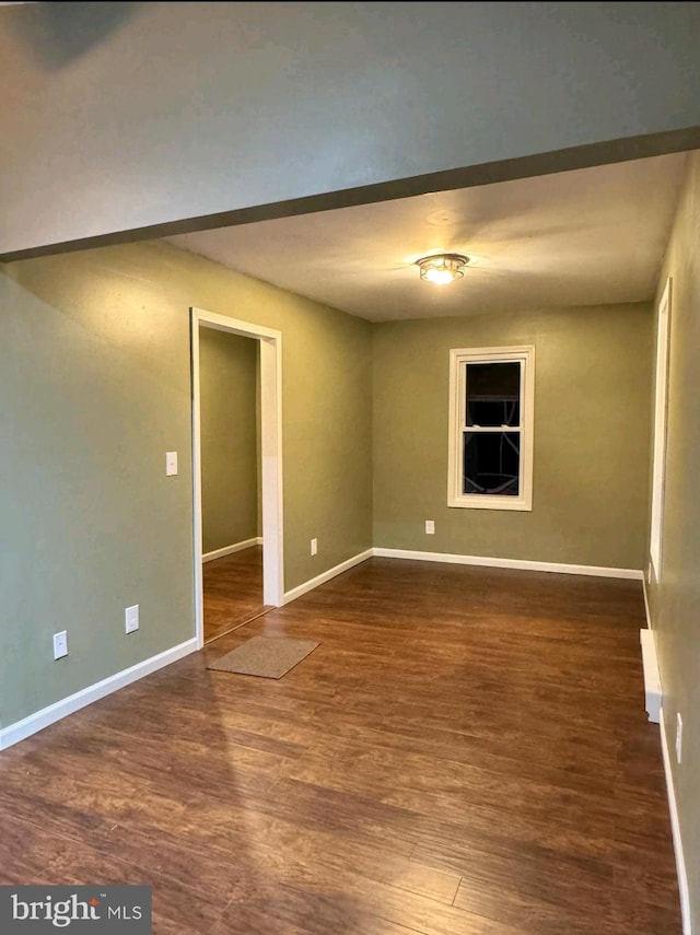 unfurnished room with dark hardwood / wood-style flooring