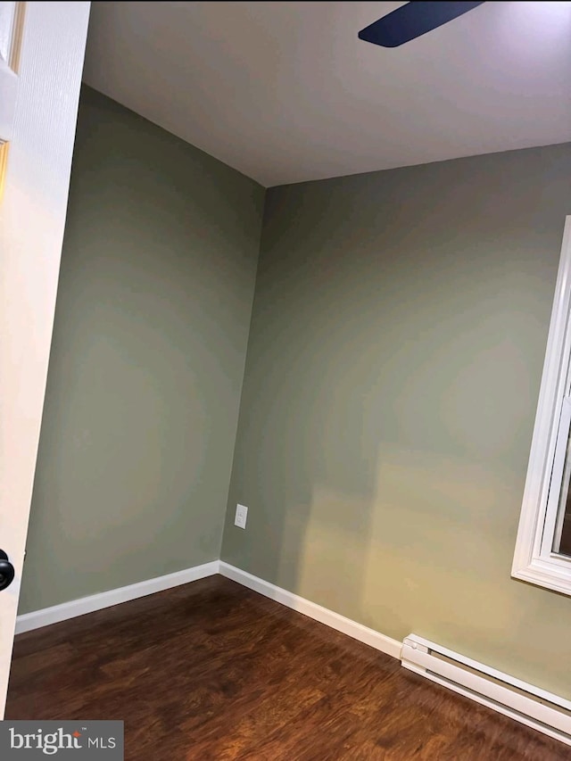 unfurnished room with ceiling fan, a baseboard radiator, and dark hardwood / wood-style floors