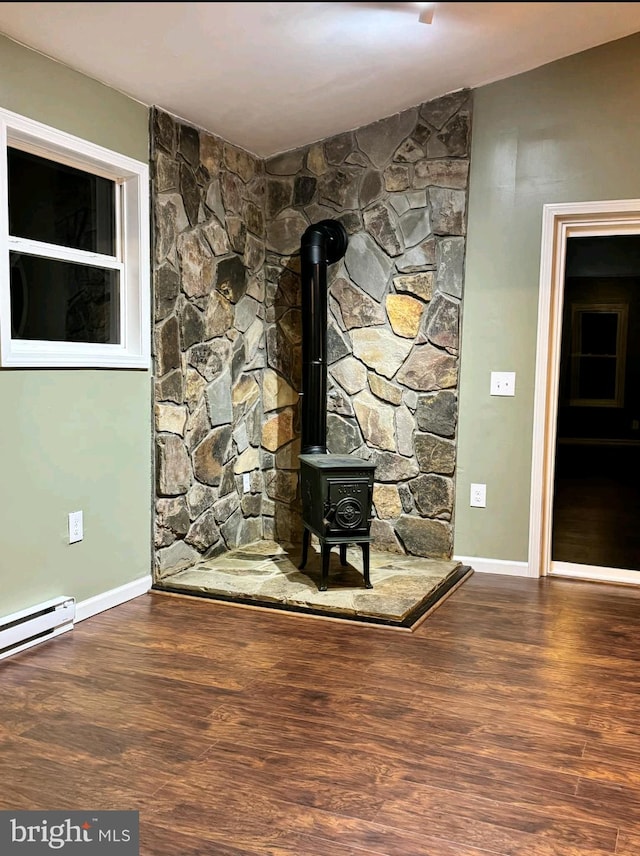 interior details with hardwood / wood-style floors, a baseboard radiator, and a wood stove