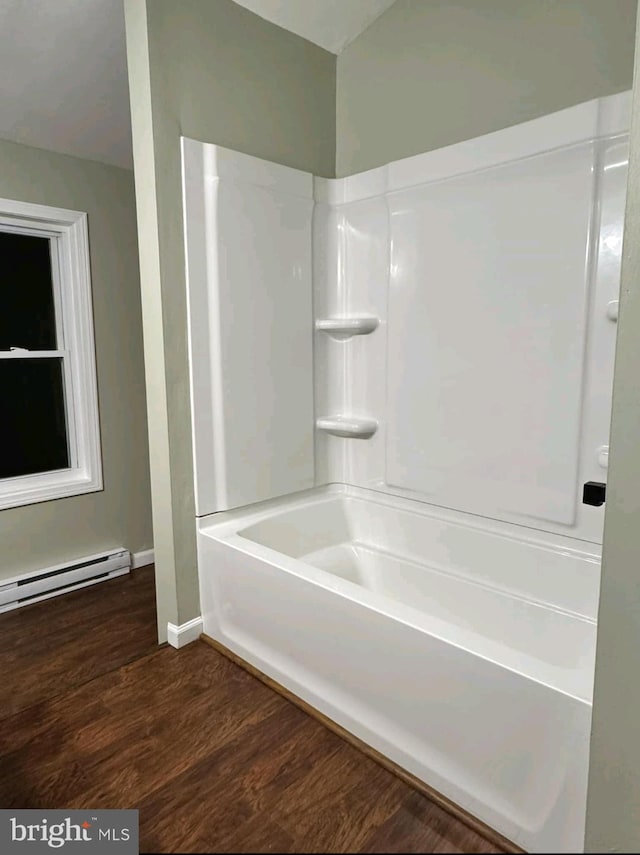 bathroom with wood-type flooring,  shower combination, and a baseboard heating unit