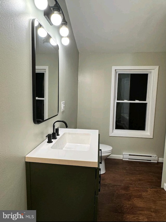 bathroom featuring baseboard heating, vanity, toilet, and hardwood / wood-style flooring