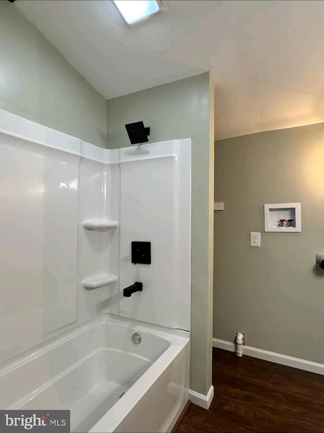 bathroom with hardwood / wood-style flooring and shower / bathtub combination