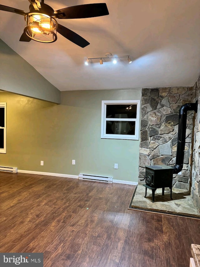 basement featuring hardwood / wood-style flooring, a baseboard radiator, ceiling fan, and a wood stove