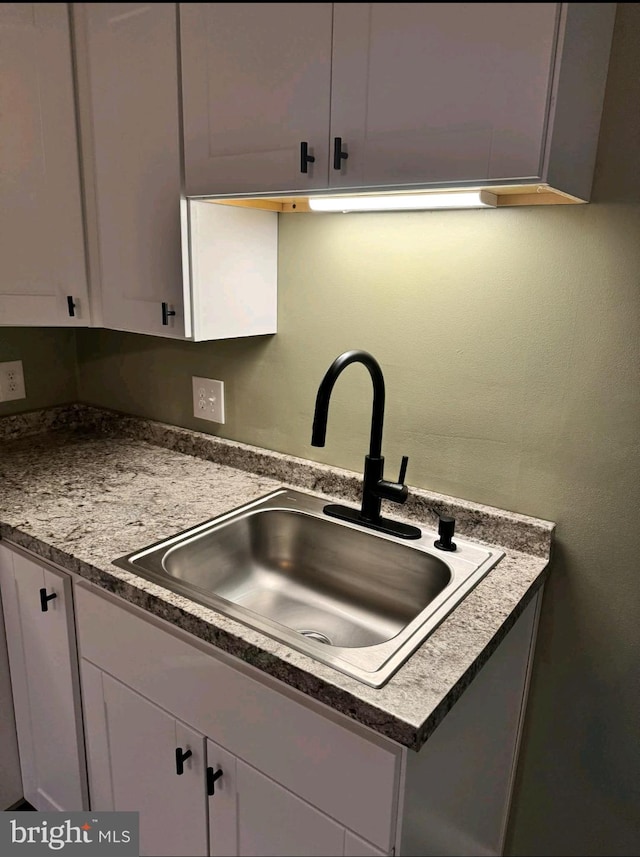 kitchen featuring white cabinetry and sink