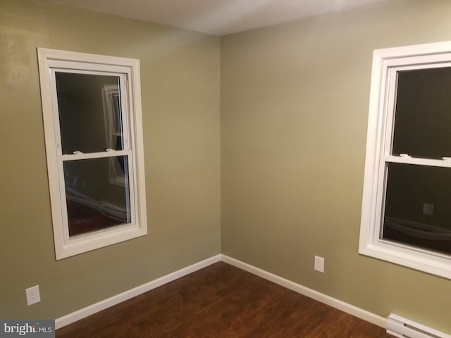 unfurnished room featuring a baseboard radiator and dark hardwood / wood-style floors