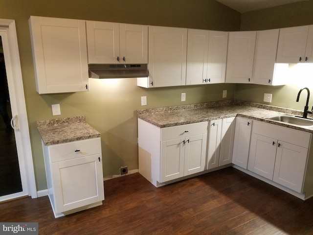 kitchen featuring white cabinetry, dark hardwood / wood-style flooring, light stone countertops, and sink