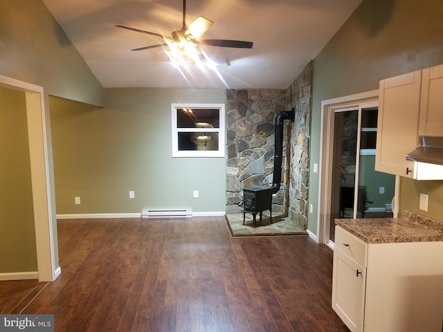 unfurnished living room with dark wood-type flooring, a baseboard radiator, vaulted ceiling, and a wood stove