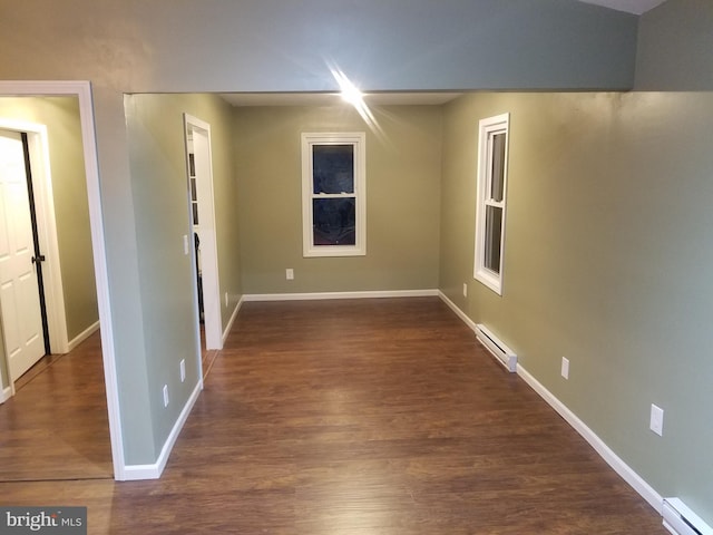 spare room featuring dark hardwood / wood-style flooring and baseboard heating