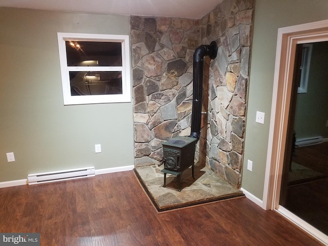 room details with a baseboard radiator, wood-type flooring, and a wood stove