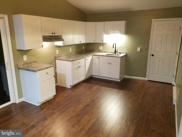 kitchen featuring lofted ceiling, sink, light stone counters, dark hardwood / wood-style flooring, and white cabinets