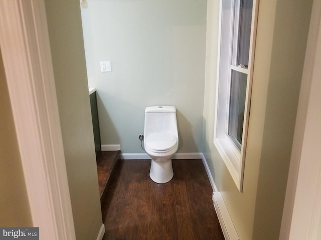 bathroom with hardwood / wood-style floors, baseboard heating, and toilet