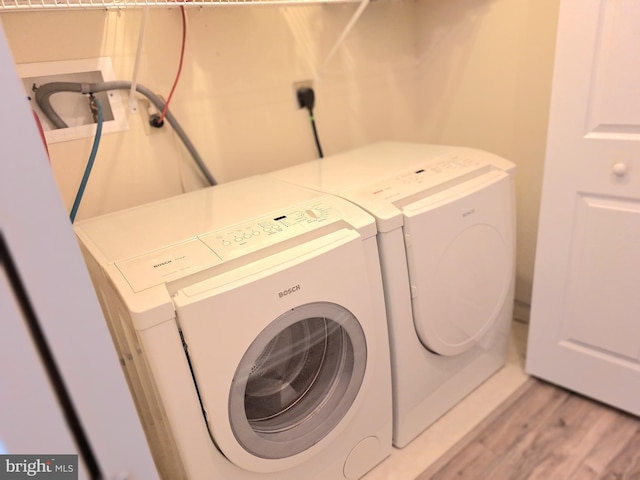 washroom featuring washer and clothes dryer and light wood-type flooring