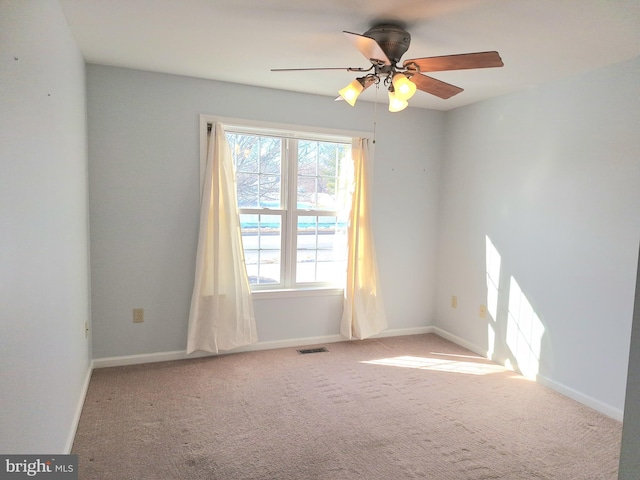 carpeted spare room featuring ceiling fan