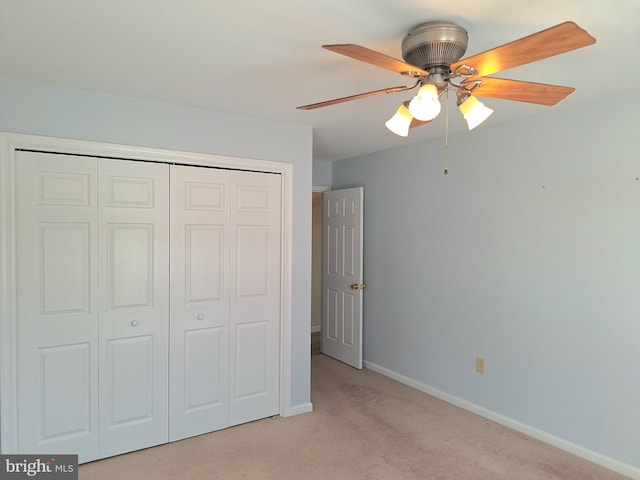 unfurnished bedroom with ceiling fan, light carpet, and a closet