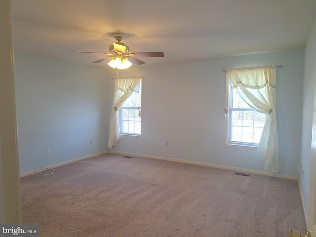 carpeted empty room with ceiling fan and a healthy amount of sunlight