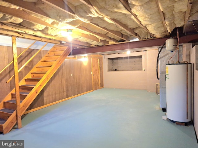 basement with water heater and wood walls