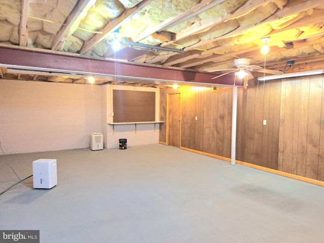 basement featuring wood walls