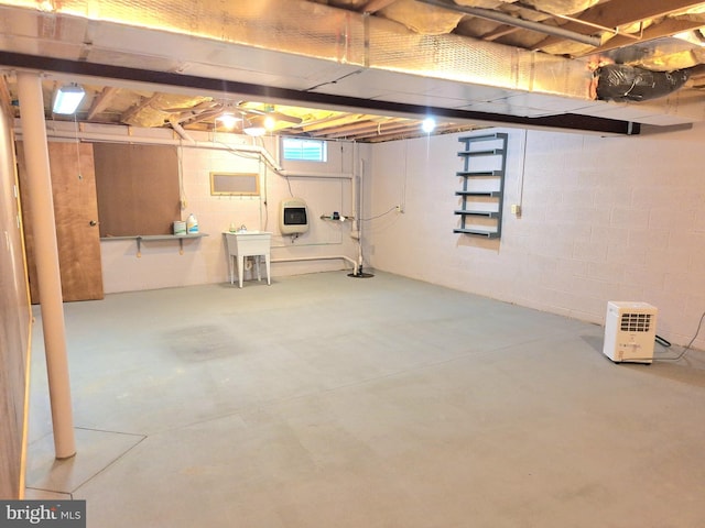 basement featuring sink and heating unit