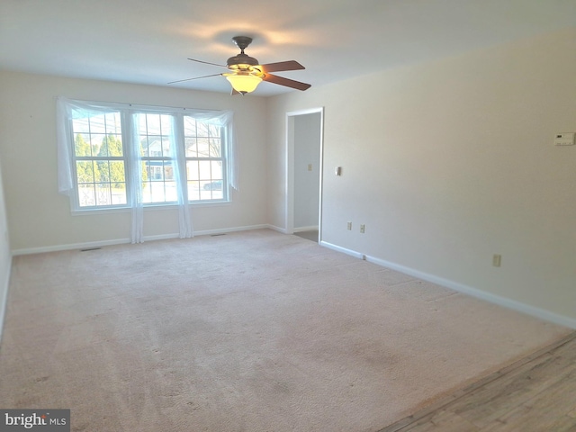 spare room featuring light carpet and ceiling fan