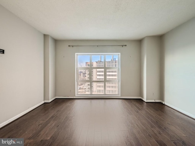 spare room with dark hardwood / wood-style flooring and a textured ceiling