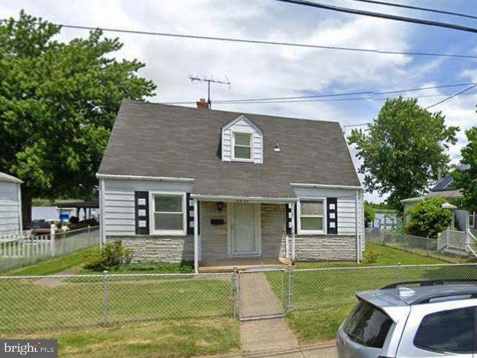 cape cod-style house with a front yard