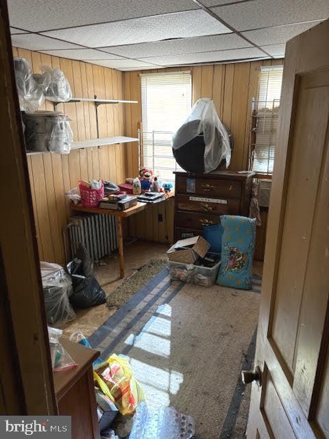 miscellaneous room featuring a paneled ceiling, a wealth of natural light, and wooden walls