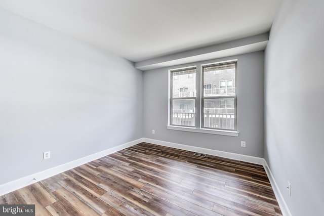 spare room with dark hardwood / wood-style floors