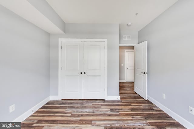 unfurnished bedroom featuring dark hardwood / wood-style floors and a closet