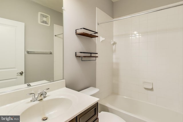 full bathroom with vanity, tiled shower / bath combo, and toilet