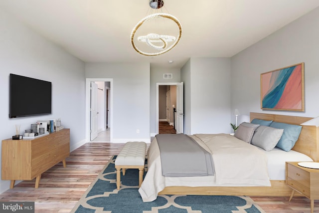 bedroom with hardwood / wood-style floors and a chandelier