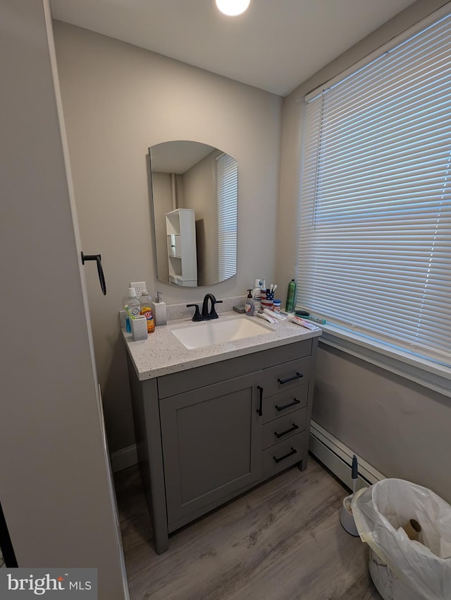 bathroom featuring a baseboard radiator, hardwood / wood-style floors, and vanity