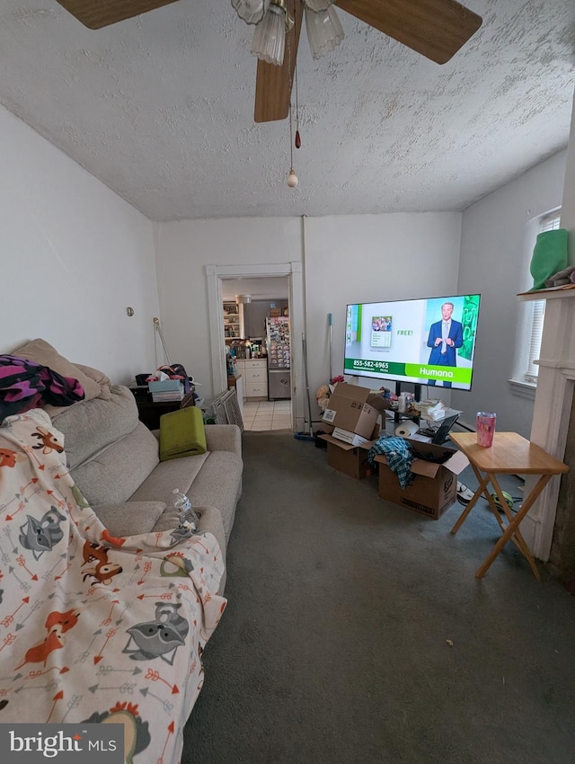 living room with ceiling fan, a textured ceiling, and carpet