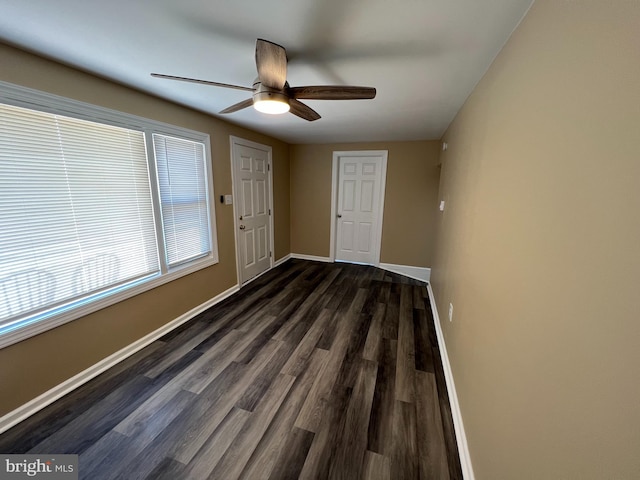 empty room with dark hardwood / wood-style floors and ceiling fan