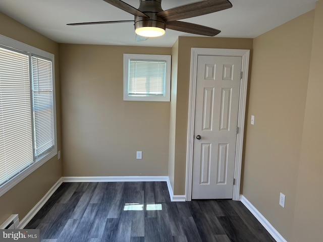 spare room with a baseboard radiator, ceiling fan, and dark hardwood / wood-style flooring