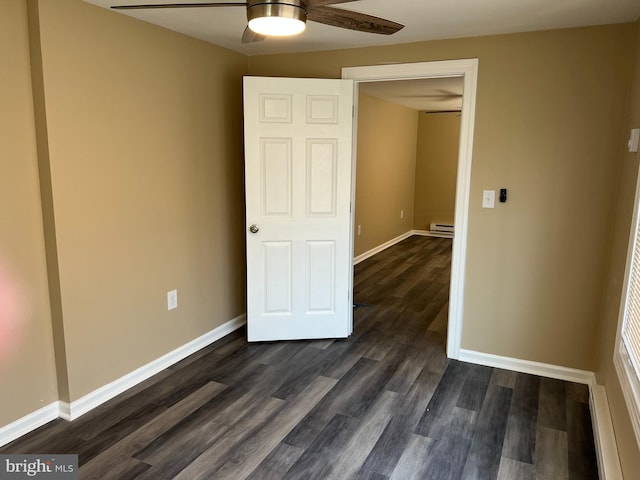 unfurnished bedroom with baseboard heating, ceiling fan, and dark hardwood / wood-style flooring