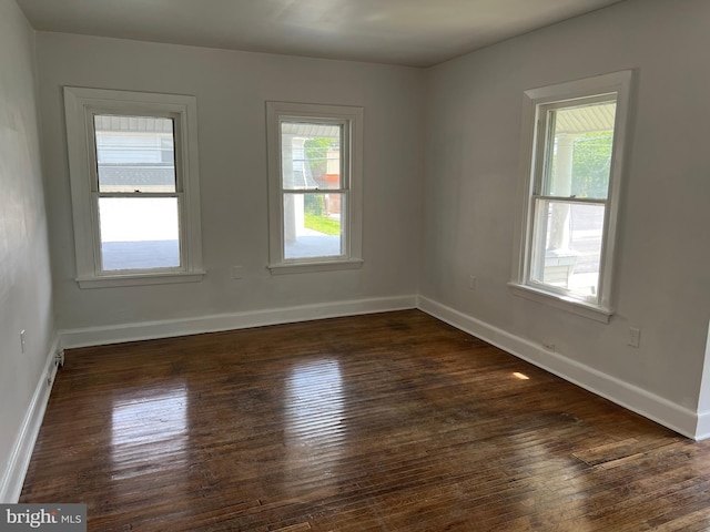 unfurnished room with dark hardwood / wood-style flooring