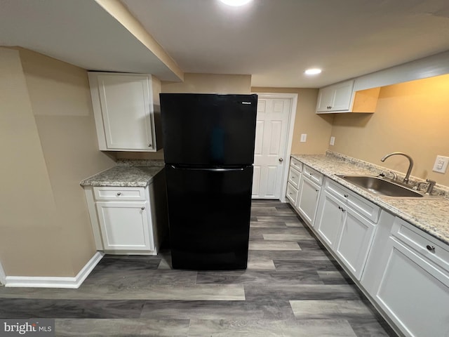 kitchen featuring black fridge, sink, dark wood-type flooring, and white cabinets