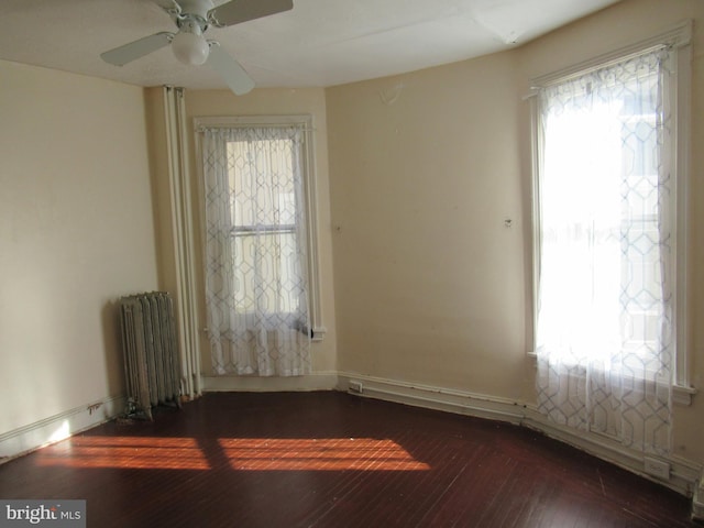 empty room with radiator, dark wood-type flooring, and ceiling fan