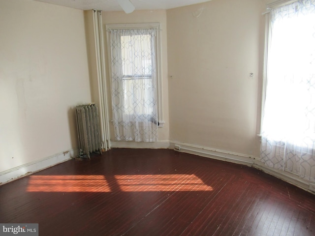 unfurnished room featuring dark wood-type flooring and radiator