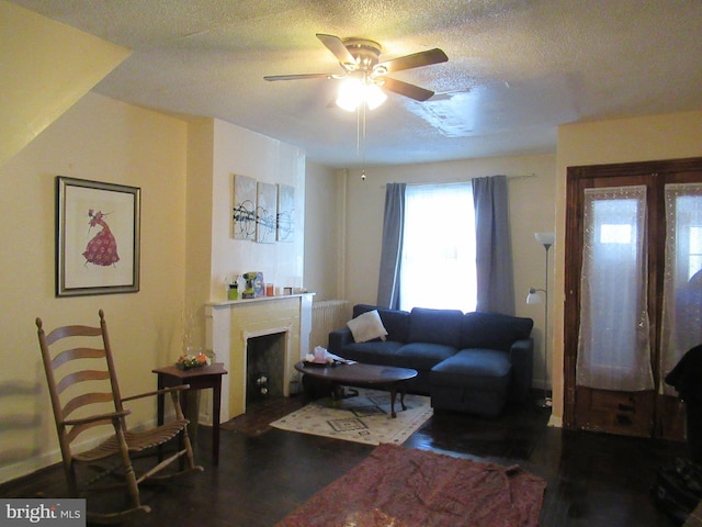 living room featuring ceiling fan and a textured ceiling