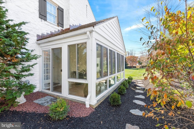 view of property exterior with a sunroom