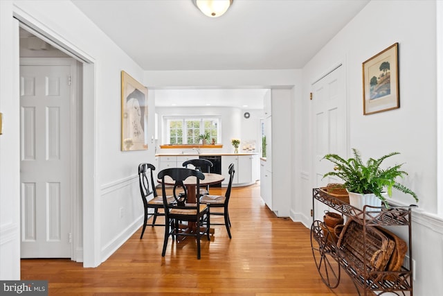 dining area featuring sink and light wood-type flooring