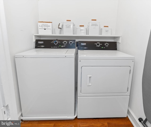 laundry room featuring washer and clothes dryer and wood-type flooring