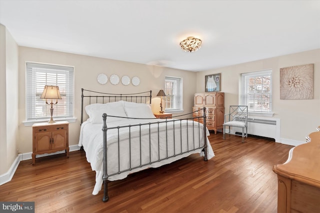 bedroom featuring hardwood / wood-style floors and radiator heating unit