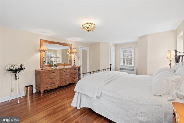 bedroom featuring hardwood / wood-style flooring and a wall mounted air conditioner