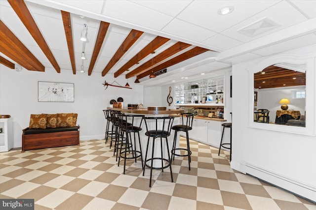 bar featuring a baseboard heating unit, white cabinets, and beam ceiling